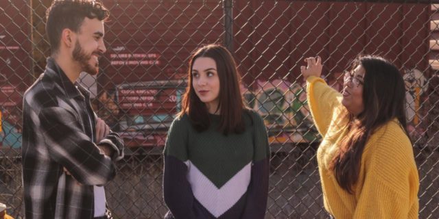 photo of three teens talking by chainlink fence