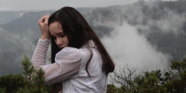 Decatastrophizing: How to Calm Down When the World Is Caving In photo of woman looking worried in front of misty mountains