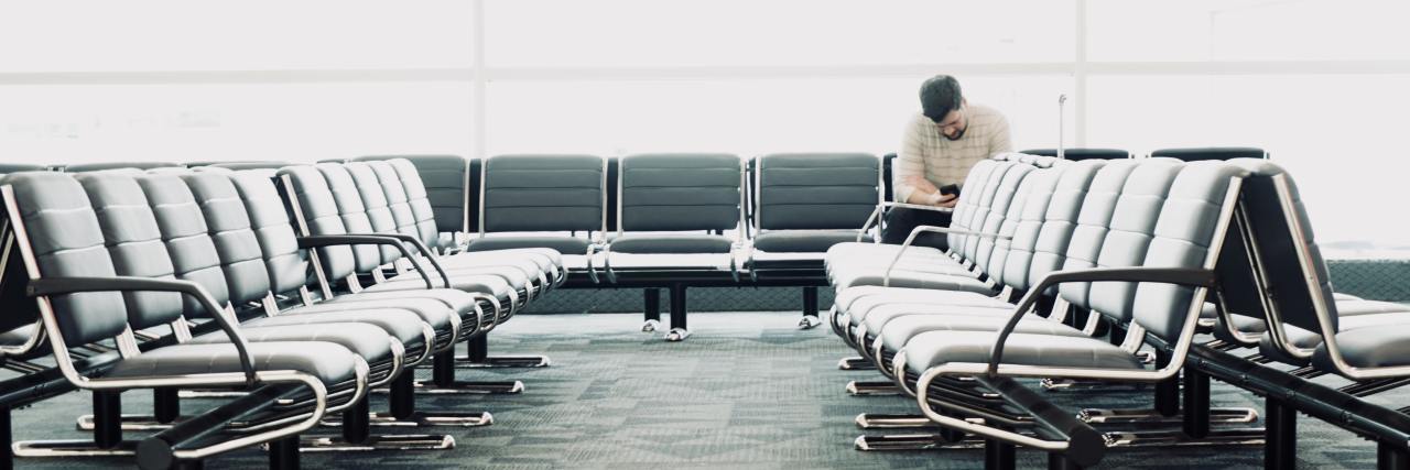 Coping With a Stressful Day With Schizophrenia photo of a man sitting in a waiting room with large glass windows and lots of light