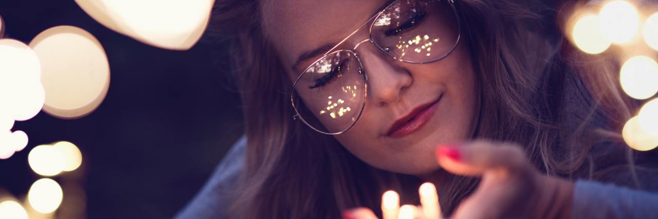 Totally Free Self-Care Ideas for Depression and Anxiety photo of woman with closed eyes, holding fairy lights in her hand and smiling