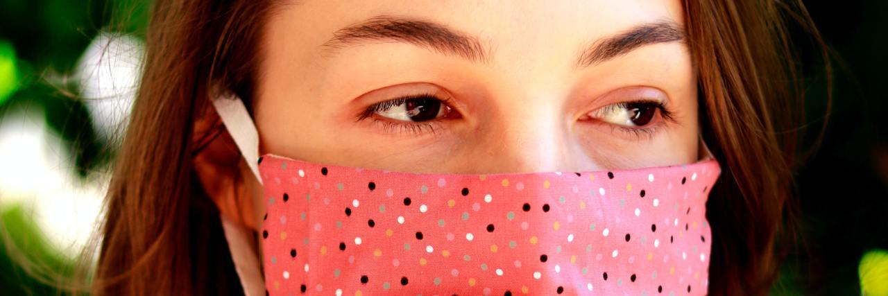 Waiting for the COVID-19 Vaccine is Impacting My Mental Health photo of young woman wearing a pink face mask with dotted design