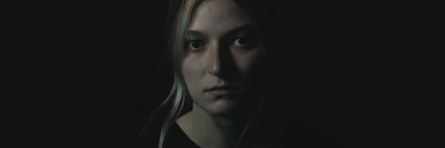 dark photo of a woman looking upset into camera