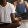 Image of Black man and White man sitting in meditative pose