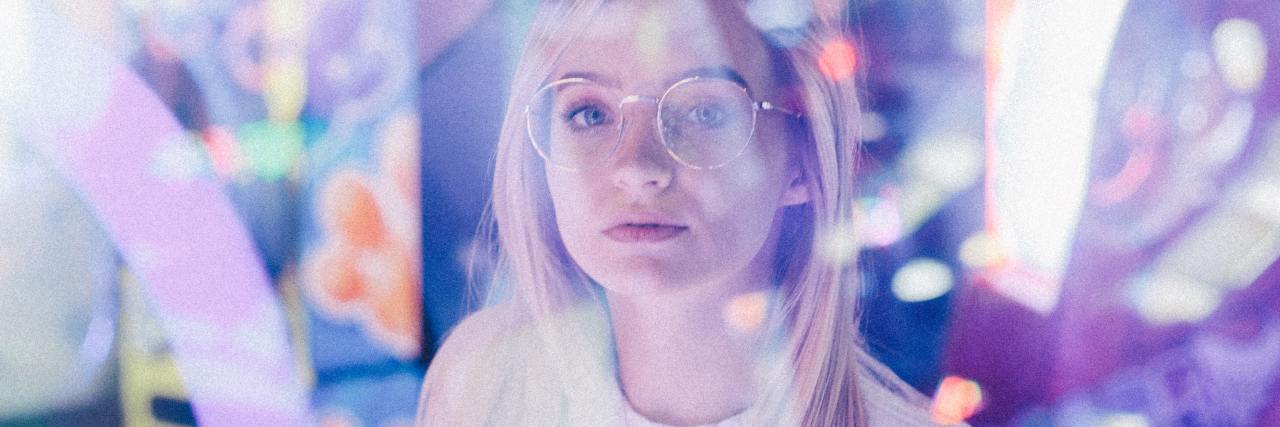 photo of a woman taken through a window with bright lights and reflections