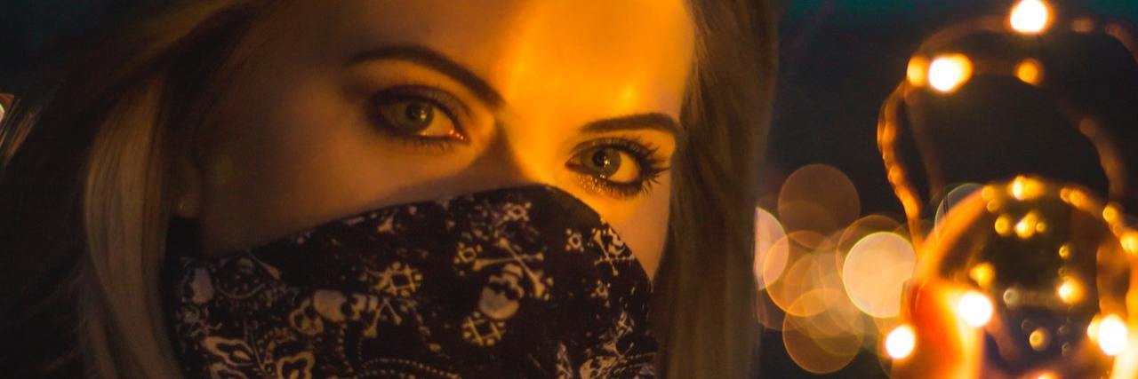 Reminders About Grief One Year After COVID-19 Began A woman with a bandana covering her face