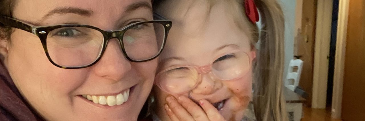 Raising a Child With Down Syndrome During the COVID-19 Pandemic Kristin and her daughter in the kitchen wearing aprons.