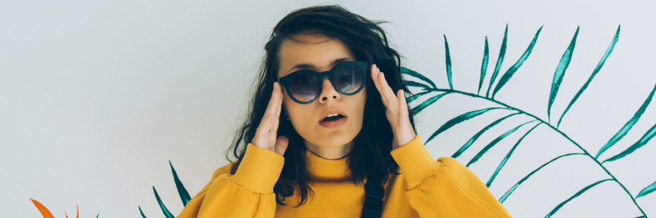 Chronic Illness: My Full-Time, Lifelong, Never-Ending Job oman in sunglasses, belt bag and sweatshirt.