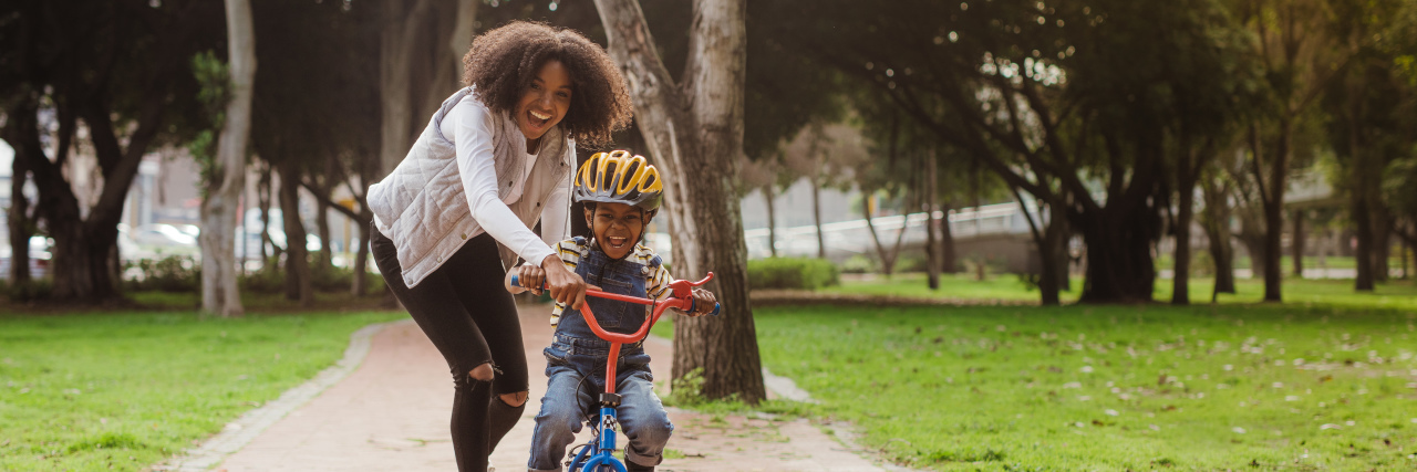 Tips for Parents of Kids With ADHD Boy learning to ride a bicycle with his mother.