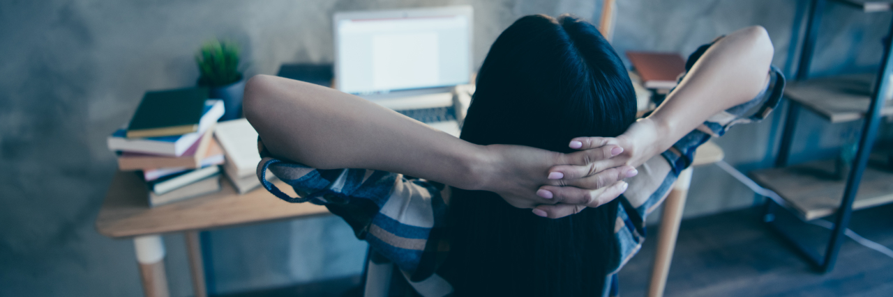 Thoughts About Lockdown Learning From a Homeschool Abuse Survivor behind view of a woman looking at her laptop at a desk