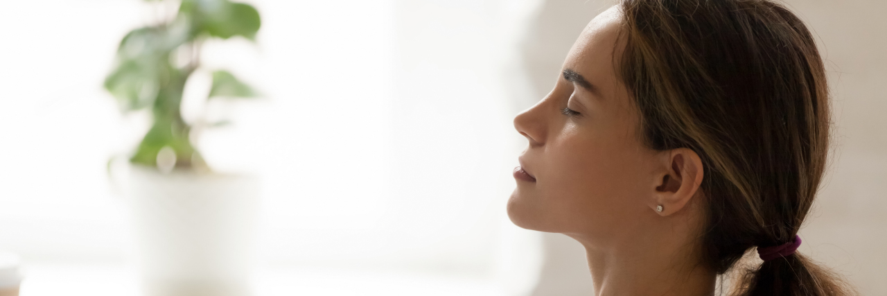Tips for When Pandemic Anxiety Is Out of Control side view of a young woman with her eyes closed relaxing