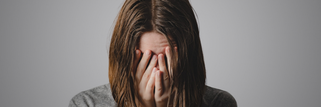 When You Can't Get Help for a Loved One With a Serious Mental Illness Woman with her head in her hands. Concept of despair