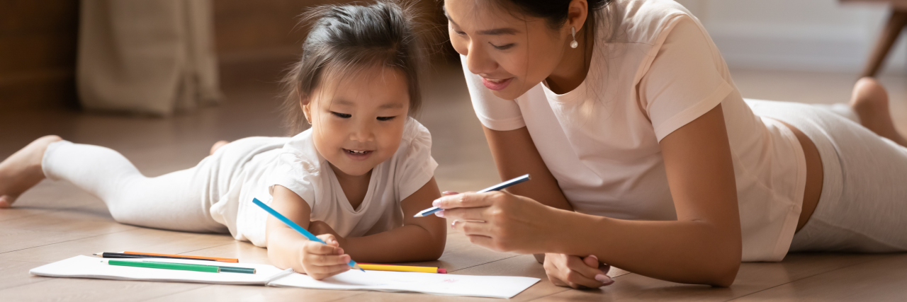 How to Support Children's Language Development During the Pandemic Young Asian mother and daughter drawing with pencils.