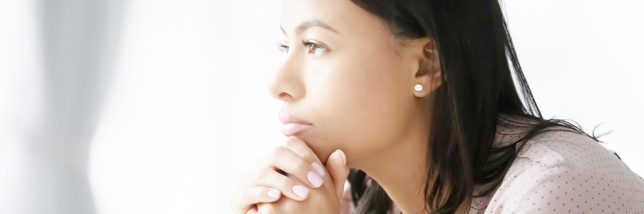 A (Sort of) Love Letter to My Chronic Pain and Cerebral Palsy Woman looking into the distance thinking.