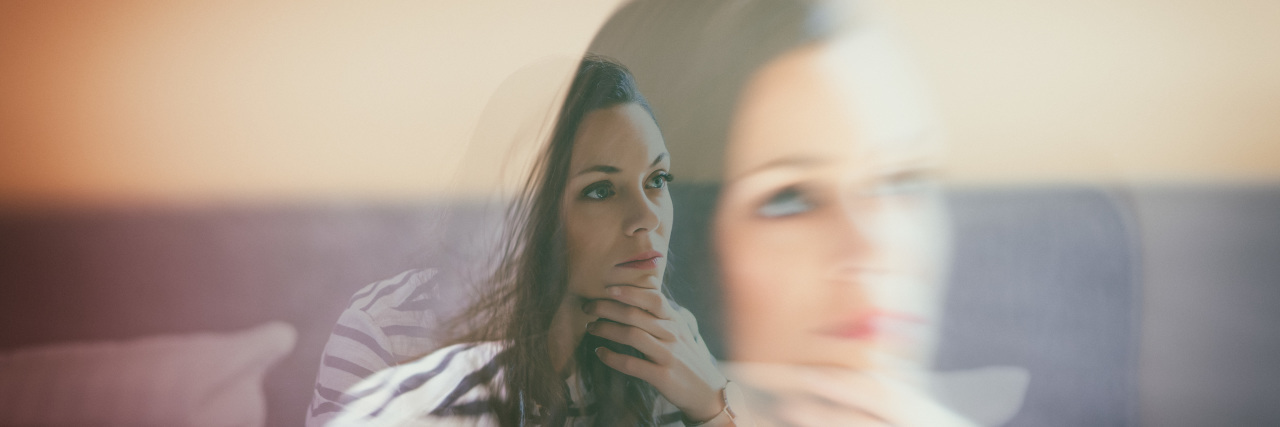 Learning to Talk About Chronic Pain With Cerebral Palsy Woman sitting on bed thinking.