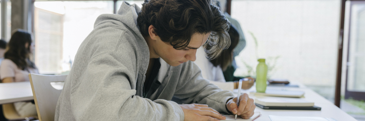 High School Student Concentrating On Written Assignment In Class