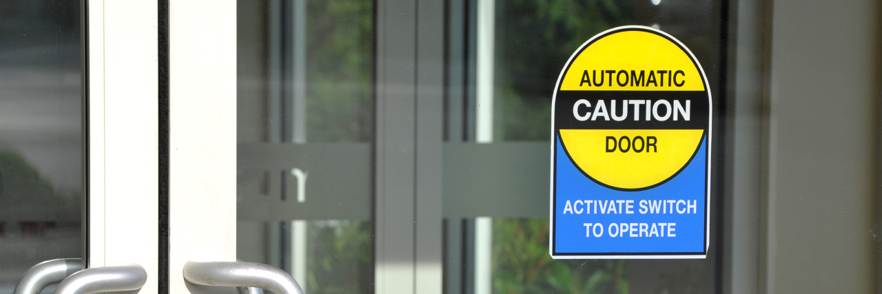 Why the ADA Needs to Require Automatic Door Openers Automatic door with caution sign.
