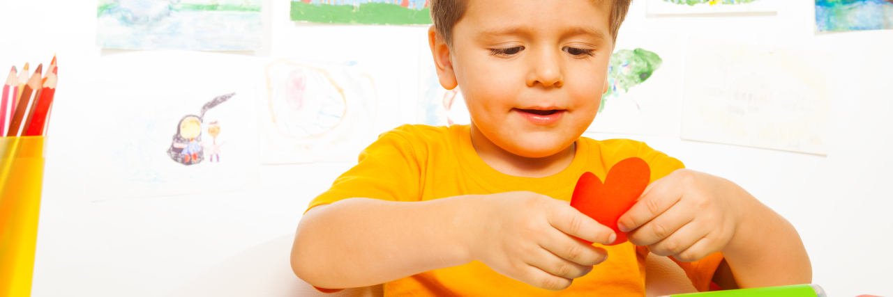 5 Life Lessons I’ve Learned From Raising an Autistic Child Happy small boy crafting paper heart.