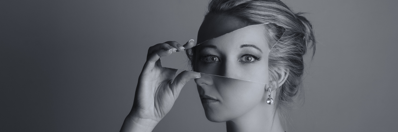 Black and white photo of a young white woman holding a broken mirror shard that reflects another set of eyes