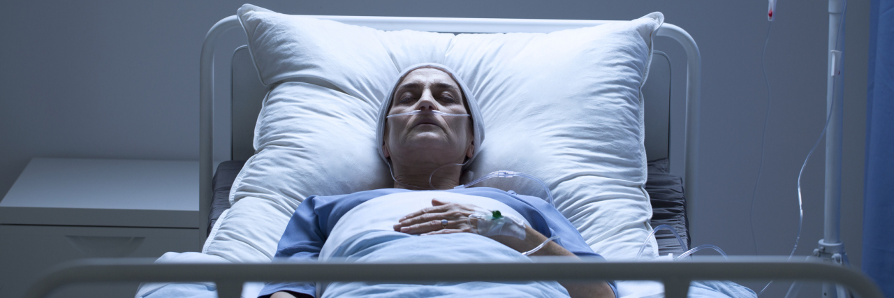 3 Things I Wish Healthcare Professionals Better Understood An older white woman in a hospital bed sleeping, dark room
