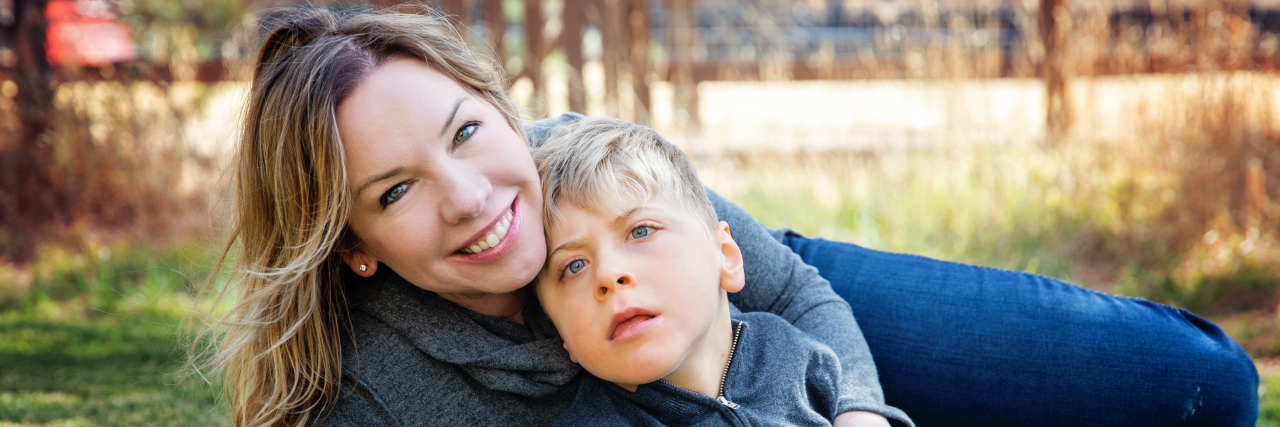 Navigating the New Landscape of Parenting a Child With Disabilities Denise and her son Brett sitting in the grass.