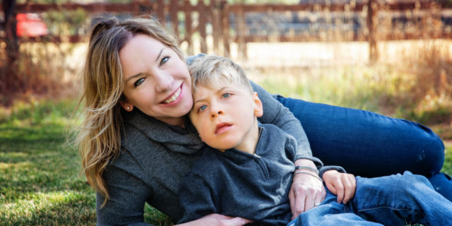 Denise and her son Brett sitting in the grass.
