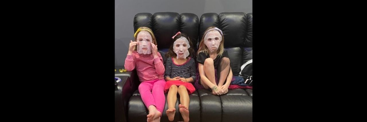 What My Daughter's First Sleepover Made Me Realize About My Depression three young girls sitting on a black couch with facial masks on at a slumber party