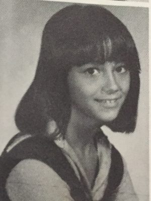 A black and white photo of the author's school picture, smiling