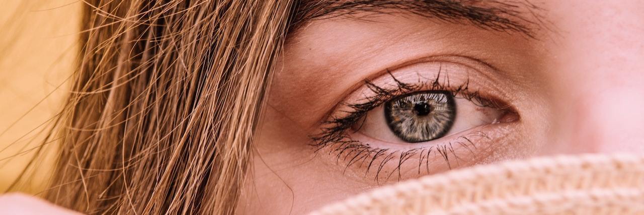 A Letter to My Dad Who Died by Suicide A woman with sad eyes holding a hat over her face, close up shot