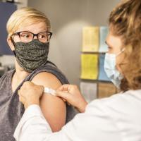 photo of a nurse and a woman after recieving a vaccine, receiving a plaster