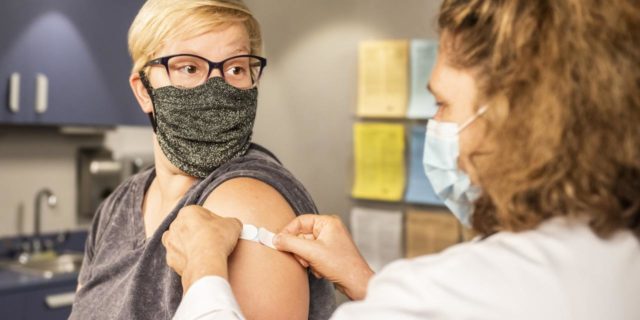 It’s OK If the COVID-19 Vaccine Triggers Your Fear of Needles photo of a nurse and a woman after recieving a vaccine, receiving a plaster