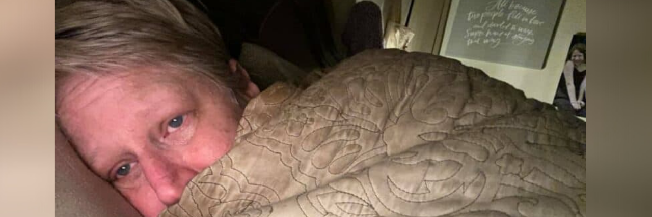 Sharing Personal Journals From Our Family's Ongoing COVID Battle Photo of contributor wrapped in blanket in bed