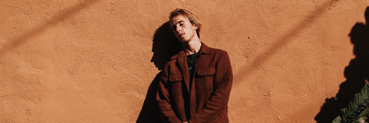 photo of a man with ginger hair leaning against a wall