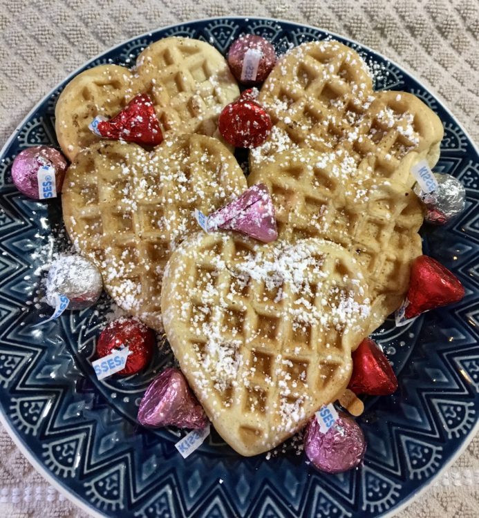 Clear image of waffles with powdered sugar and chocolate. 