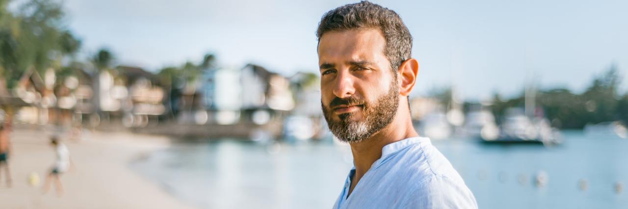 How COVID-19 Showed Me the Importance of Memories and Experiences A middle-aged man in a long sleeve shirt standing on a beach looking ahead seriously