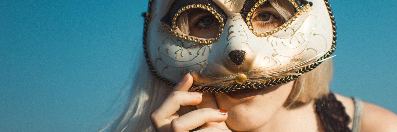 photo of a woman covering her face with a rabbit masquerade mask