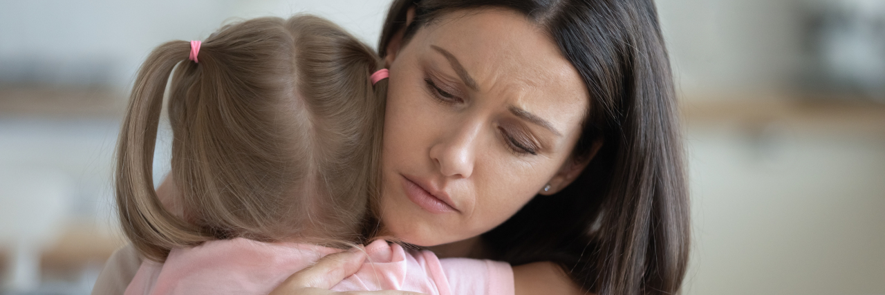 a young woman hugging a little girl with pig tails