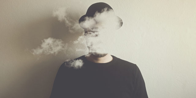 A man wearing a hat with clouds over his head