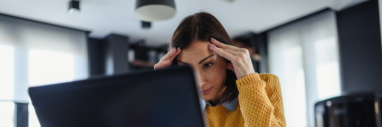 Stressed woman looking at laptop computer.