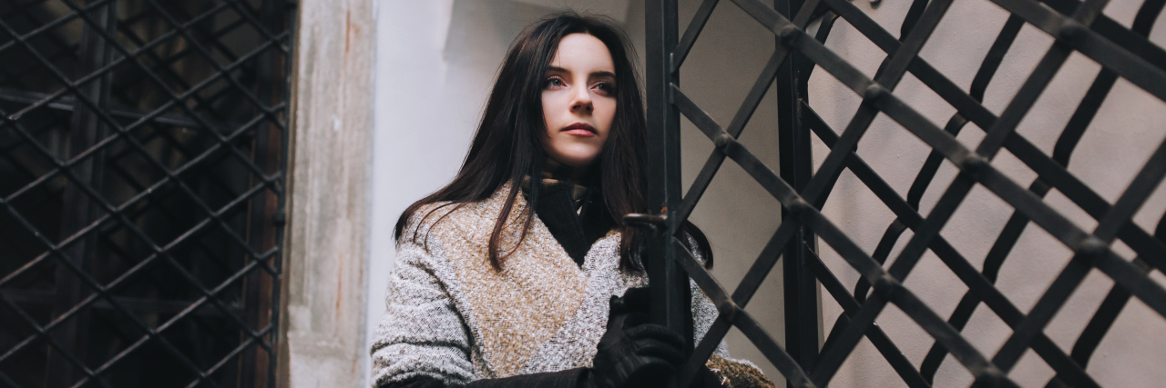 Neurotypical Gatekeeping of Autism Causes Harm Young woman opening iron gate.