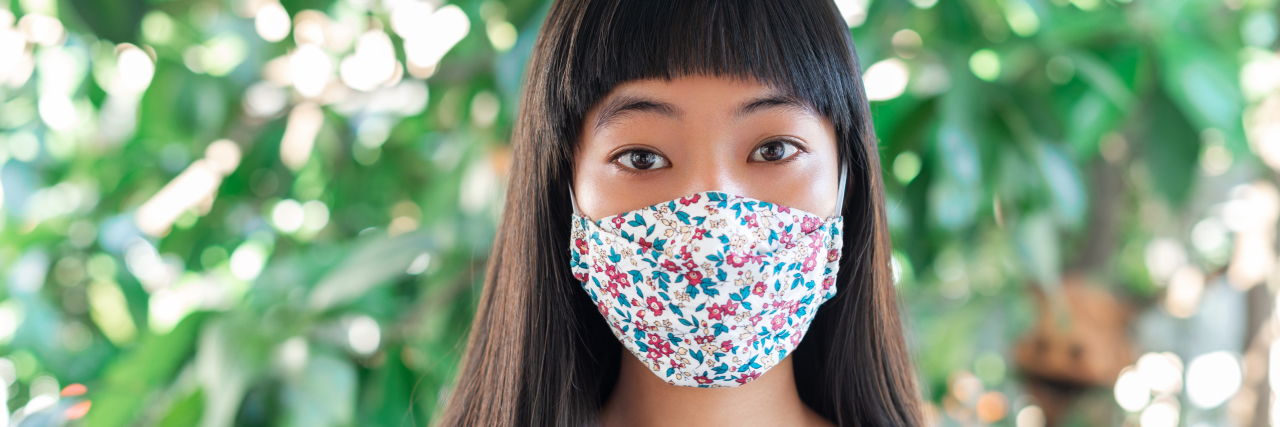 Stop Using the Disabled Community to Promote COVID Misinformation Young Asian woman wearing a face mask.