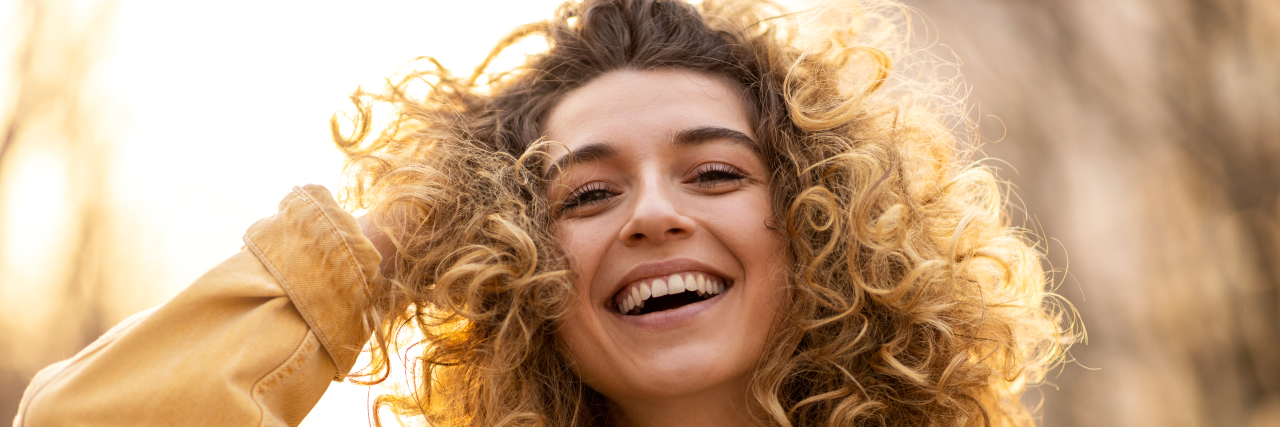 Conquering Self-Esteem Struggles in Life With a Disability Young woman with curly hair.