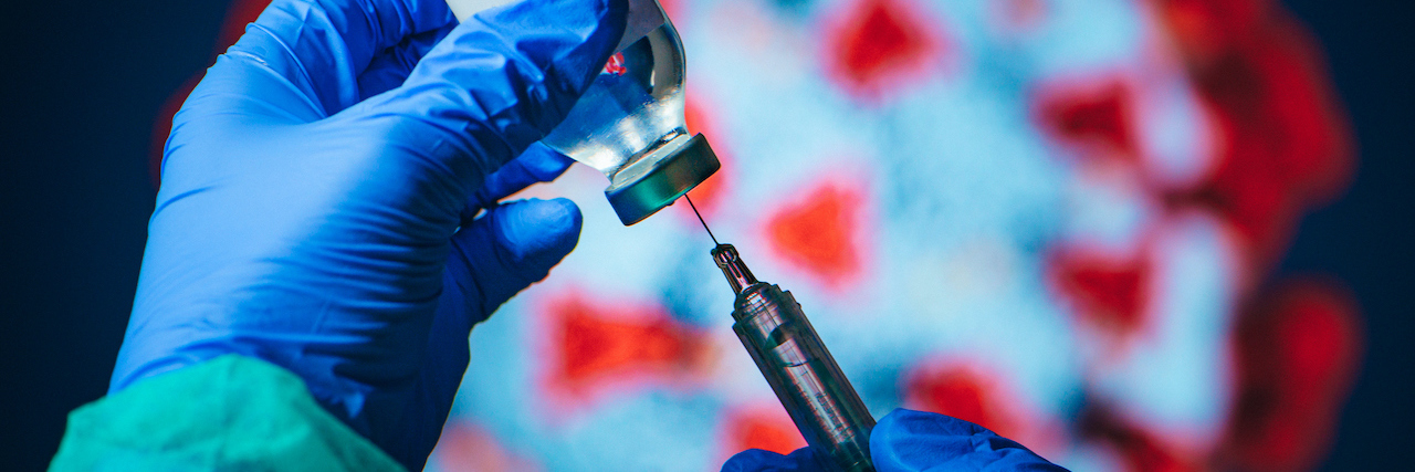 What to Know About the Johnson & Johnson COVID-19 Vaccine Pause Doctor drawing up solution from vaccine bottle and filling syringe injection for patient vaccination in medical clinic, Coronavirus in background