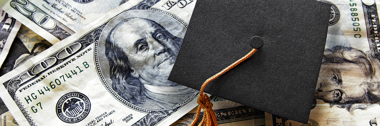 Disabled People Can Now Qualify for Student Loan Forgiveness Graduation cap on hundred dollar bills