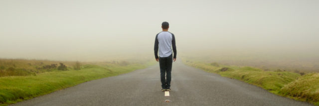 Man walking down an empty road.