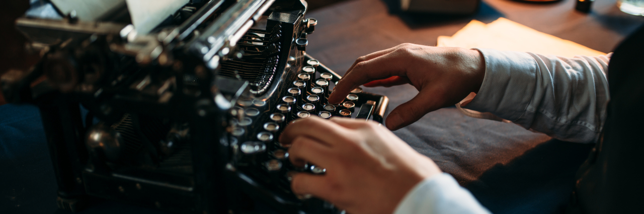 Man using old-fashioned typewriter.