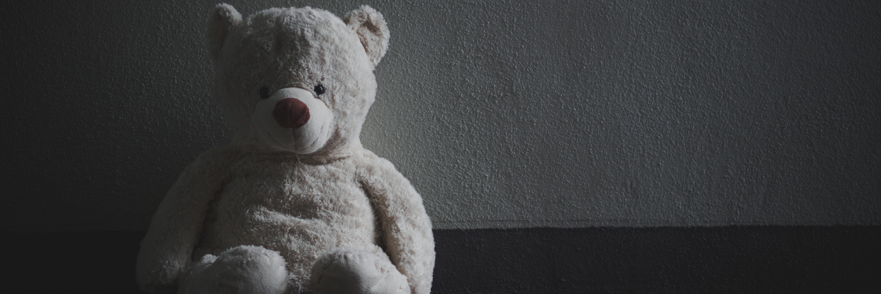 a black and white teddy bear in an empty space