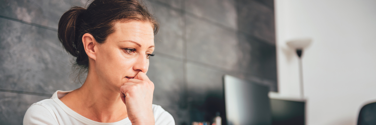 Why My Functional Neurological Disorder Diagnosis Felt Dismissive Sad woman sitting on a sofa in the living room