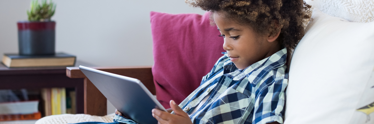 6 Considerations When Choosing an AAC Device Boy using tablet.