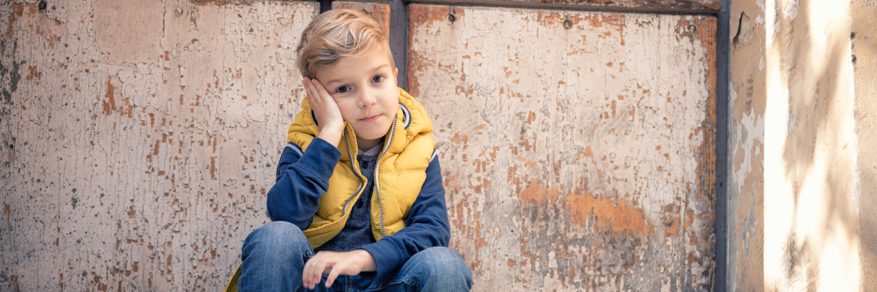 When People Are Surprised to Find Out My Son Is Autistic Thoughtful boy sitting on steps.