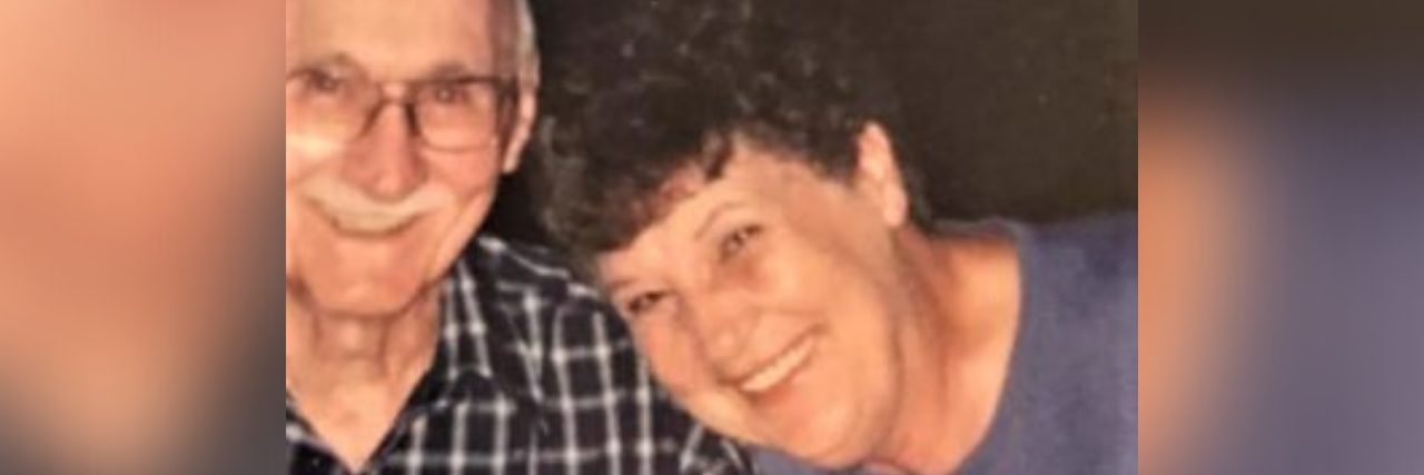 Photo of author's grandma and grandpa, an older white man with glasses smiling and his wife, an older white woman with short curly hair smiling next to him